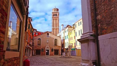 plaza de la ciudad de venecia con capilla de ladrillo y alta torre del campanario