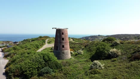 puerto amlwch ladrillo rojo en desuso abandonado molino de viento de montaña vista aérea norte de anglesey gales enfoque lento