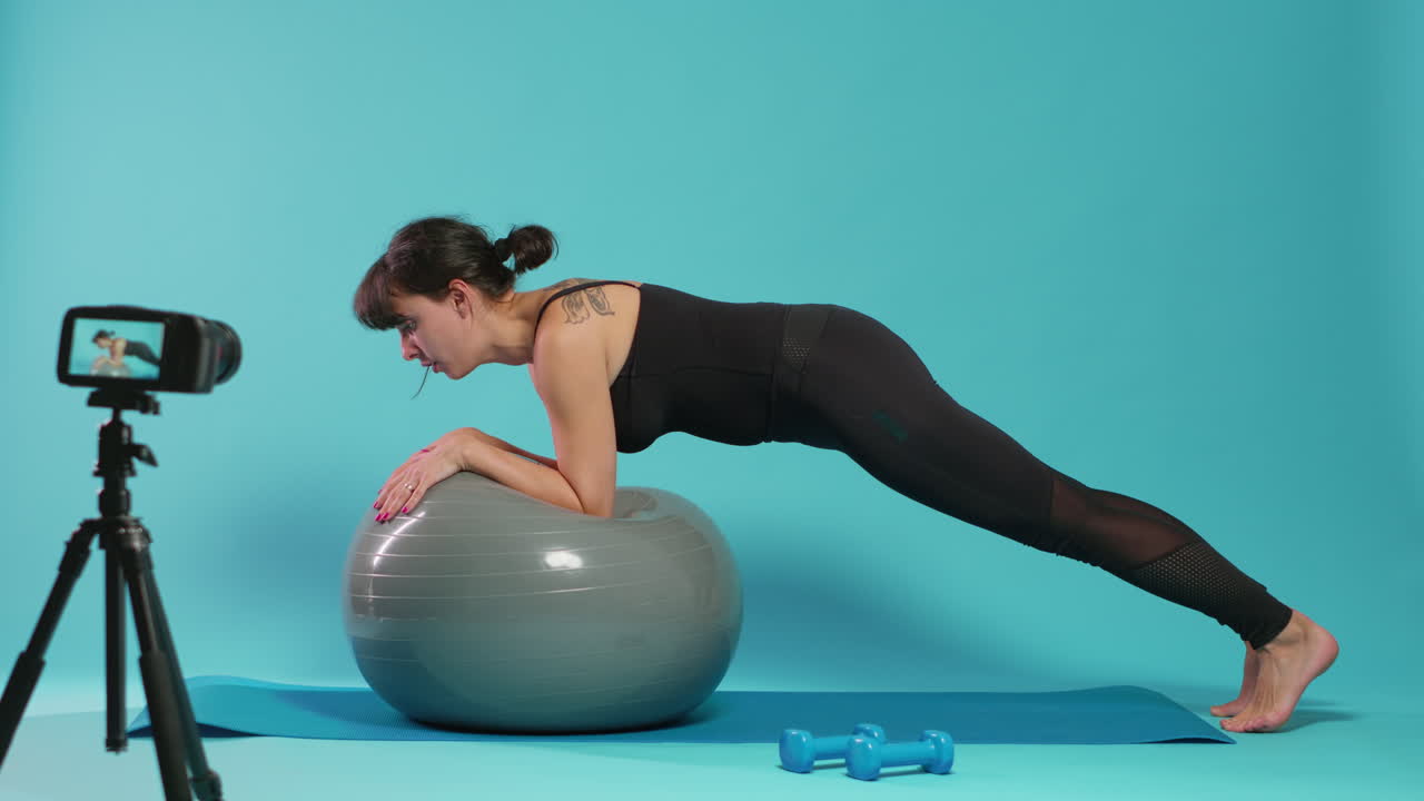 Pilates instructor explaining plank exercise on fitness toning ball