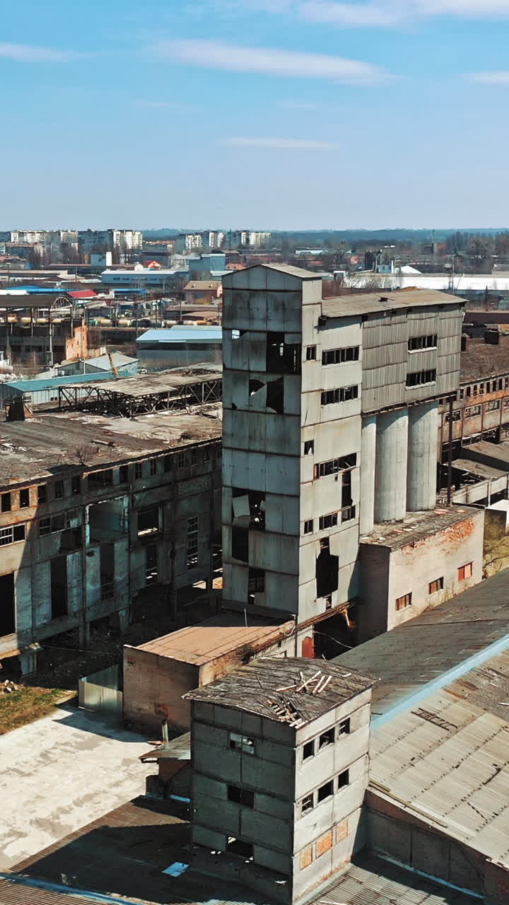 Abandoned building. Aerial view of an old factory ruin and broken windows. Vertical video