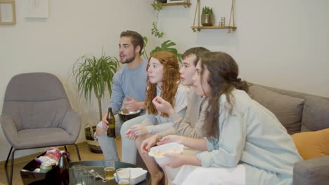 hombres y mujeres sorprendidos viendo juegos deportivos con pasión en la televisión