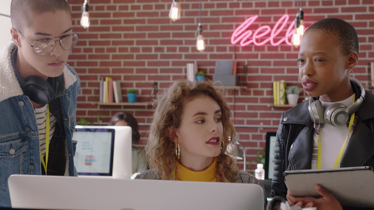 jóvenes empresarios creativos que se reúnen con líderes de equipo afroamericanos mujer que apunta a la pantalla compartir ideas lluvia de ideas discutiendo soluciones capacitación pasante usando computadora trabajo en equipo en una oficina moderna