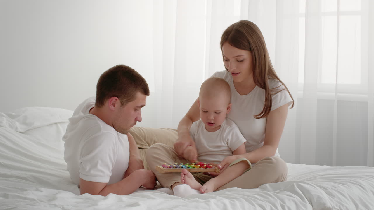 침대 위 에서 악기 를 연주 하는 가족