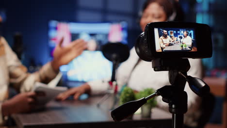 professional camera recording man in blurry background interviewing guest