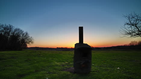 Der-Sonnenaufgang-Bricht-Hinter-Dem-Horizont-Hervor-Mit-Der-Silhouette-Eines-Vogelhauses-Im-Vordergrund---Bewegungszeitraffer