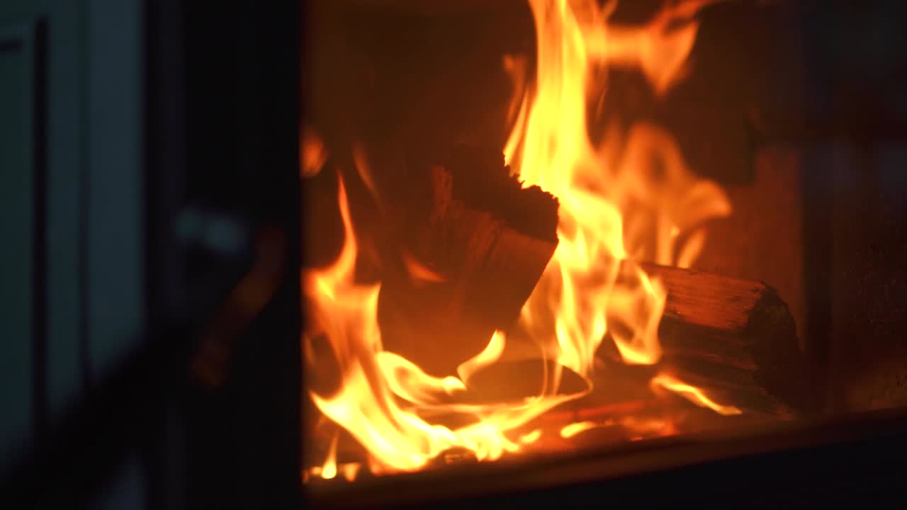 Slow motion fire burning in fire place to warm up the cabin.