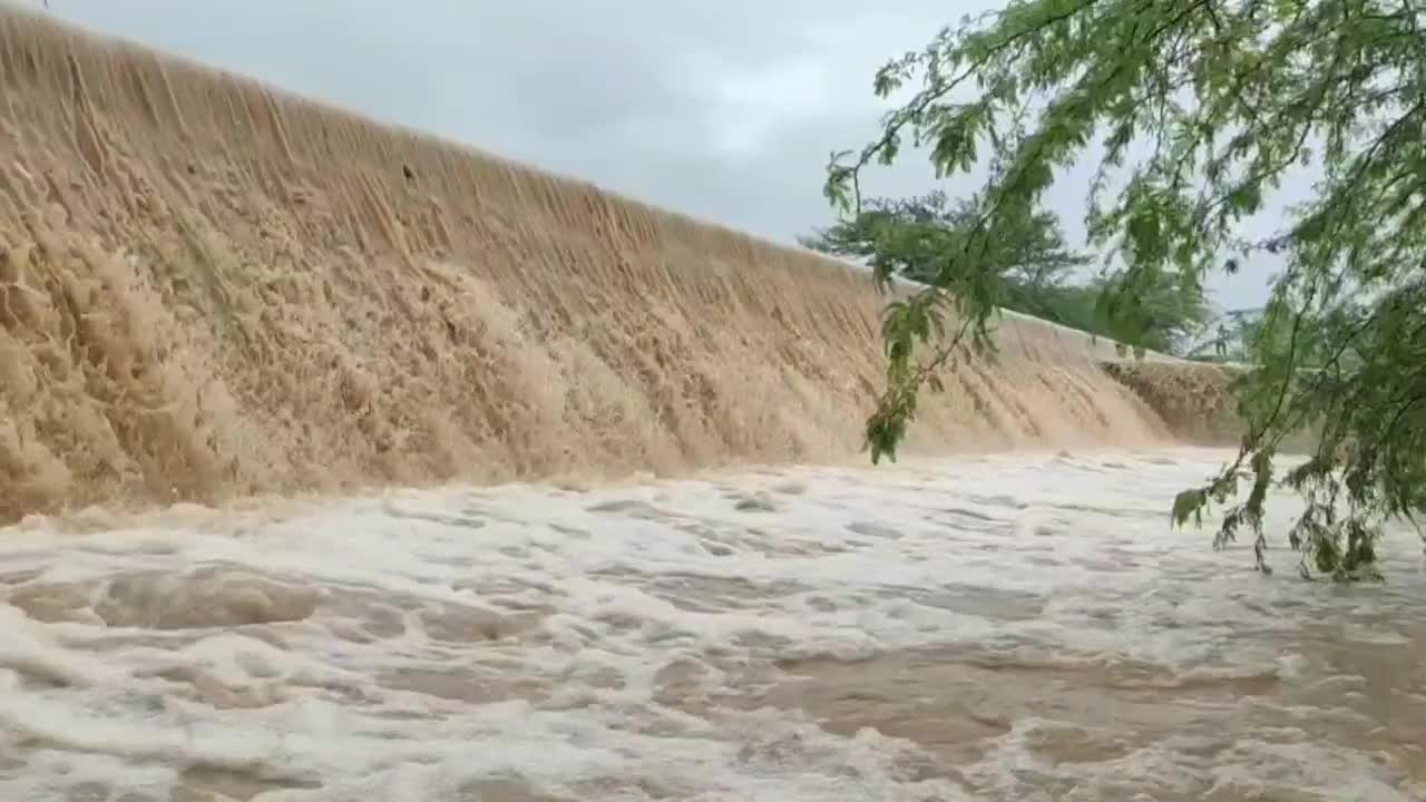 Very fast brown water falling from the dam