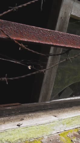 abandoned building with broken window and rusty barbed wire