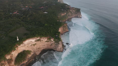 cliff meets ocean with big crashing waves
