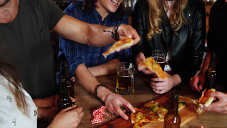 grupo de amigos interactuando mientras comen pizza