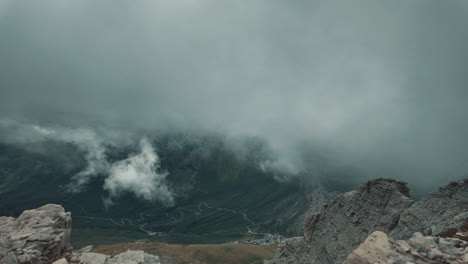 cloud movement sweeping over dramatic dolomite terrace, revealing majestic mountainous landscape at pordoi pass during serene summer daytime