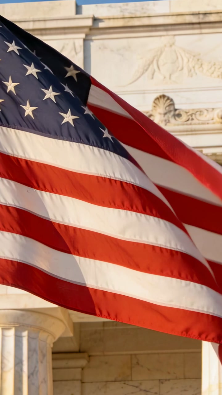 Vertical video: Billowing American flag rippling in steady breeze by marble column and stone frieze