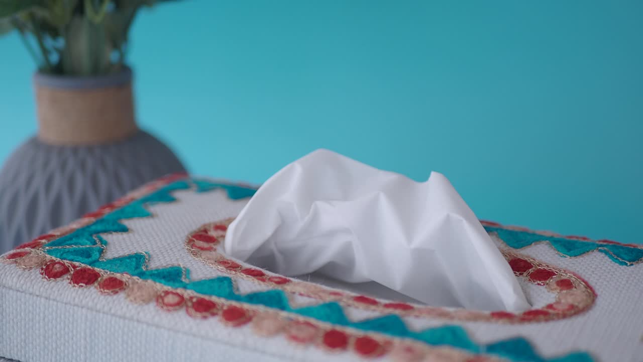 mano alcanzando para el tejido de una caja de tejido bordado decorativo