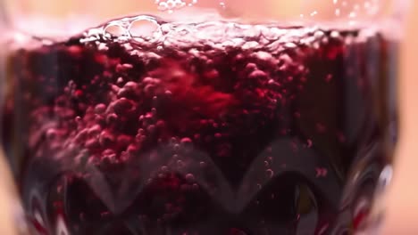 an inviting close-up view of fizzy red beverage showcasing its bubbles and textures in a glass, perfectly capturing the refreshing nature of the drink