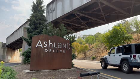 Cars-passing-the-sign-welcoming-people-to-Ashland,-Oregon
