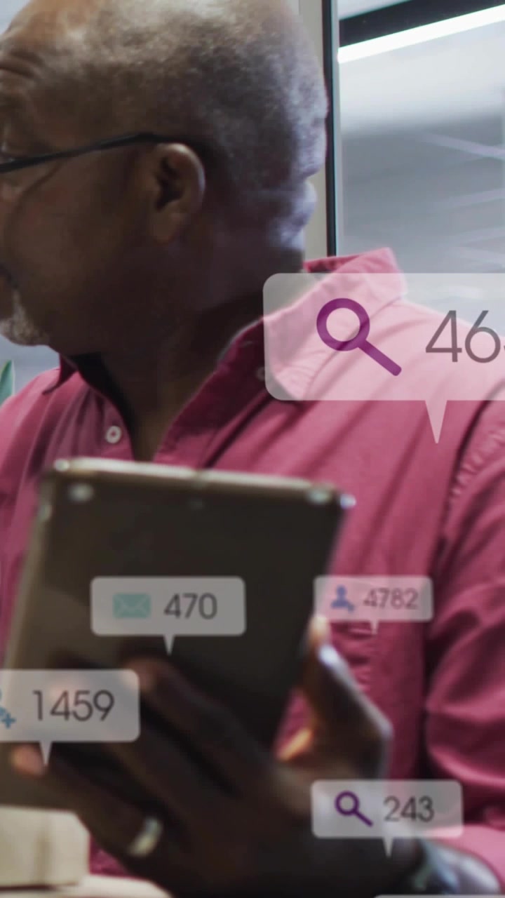 Video vertikal: Pria senior mengetuk tablet dan melihat lencana diperbarui di layar kaca untuk bisnis.
