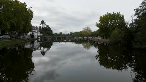 aerial pullback above river from roman bridge of aquae flaviae, chaves vila real portugal