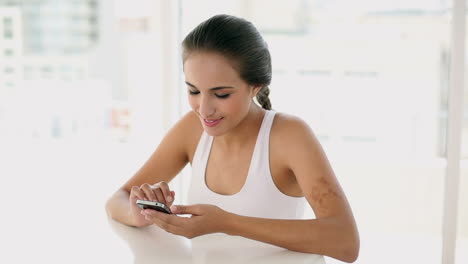 una joven hermosa enviando mensajes de texto en su teléfono.
