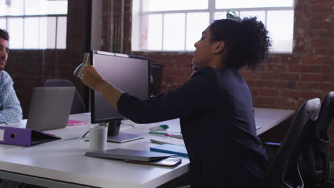 Diverse-work-colleagues-exchanging-documents-sitting-in-office-in-front-of-computer