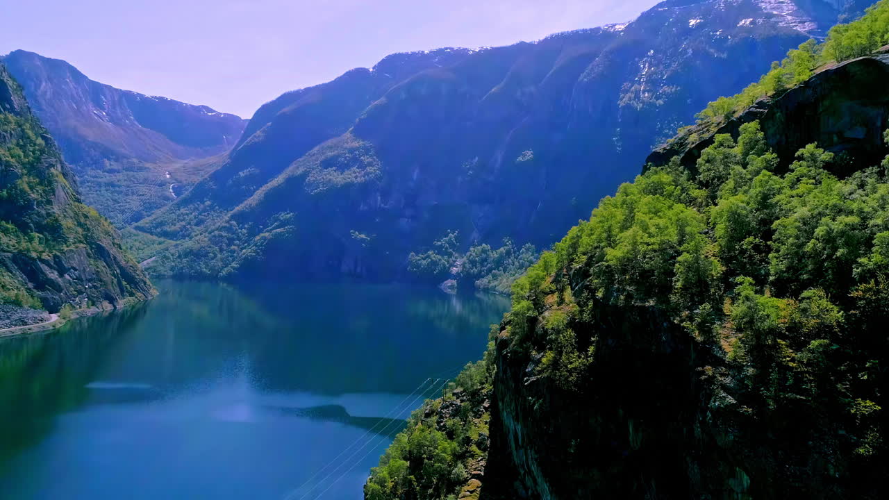 노르웨이 여름철 화창한 날 노르딕 피요르드의 푸른 산 위로 날아가는 드론