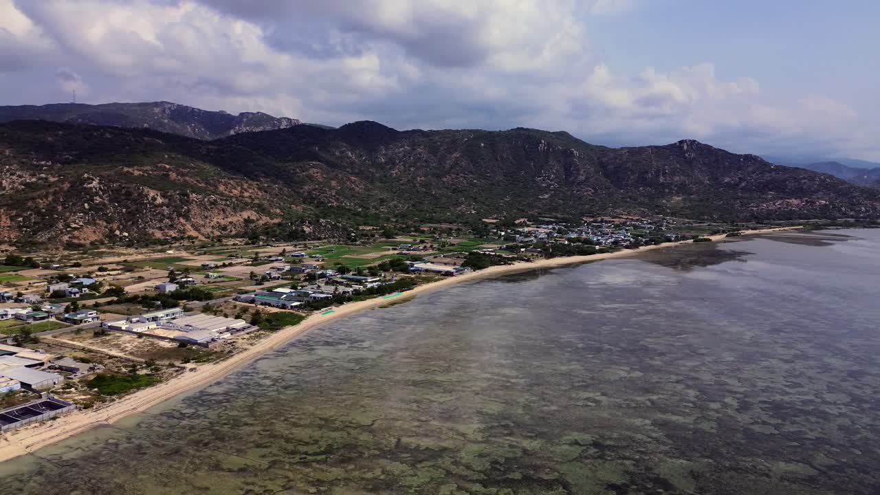 Drone aerial over My Hoa Town showing colorful rooftops and the tranquil lagoon, capturing vibrant tropical townscape in Vietnam