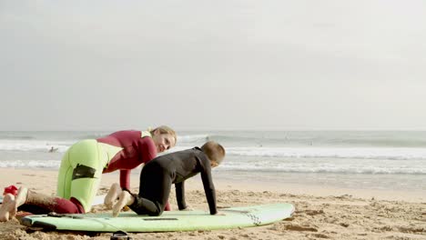 madre enseñando a su hijo pequeño a surfear