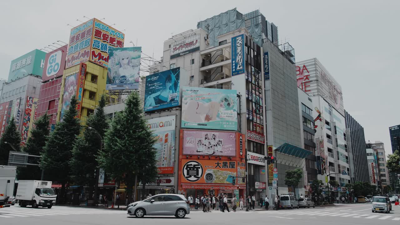 Bustling Akihabara street scene in Tokyo with prominent anime billboards and urban activity