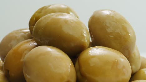 pickled round green olives from greece as background, top view. high quality 4k footage