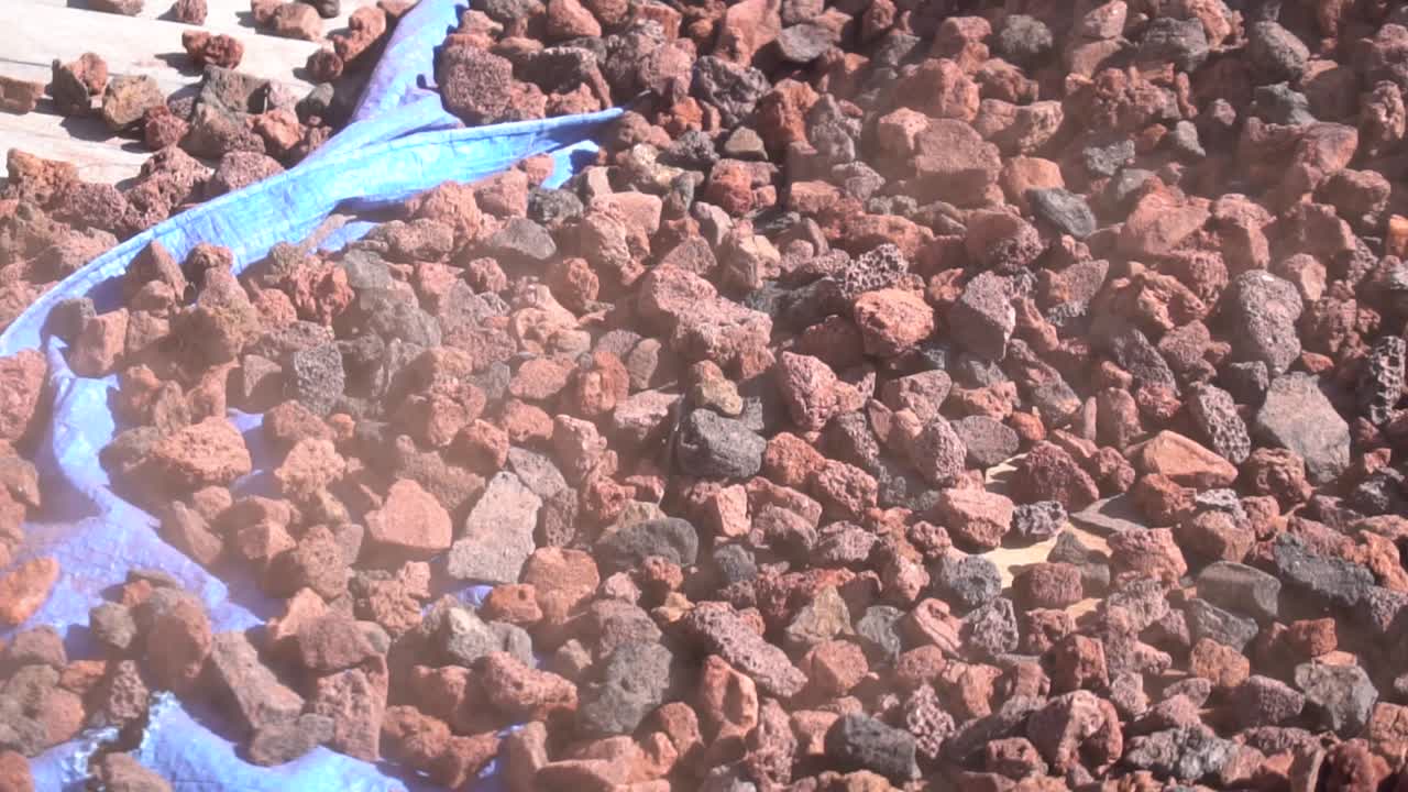 조경가 가 픽업 트럭 의 뒷면 에서 바 ⁇ 바 ⁇  로크 를 바 ⁇ 바 ⁇  로 바꾸고 있다