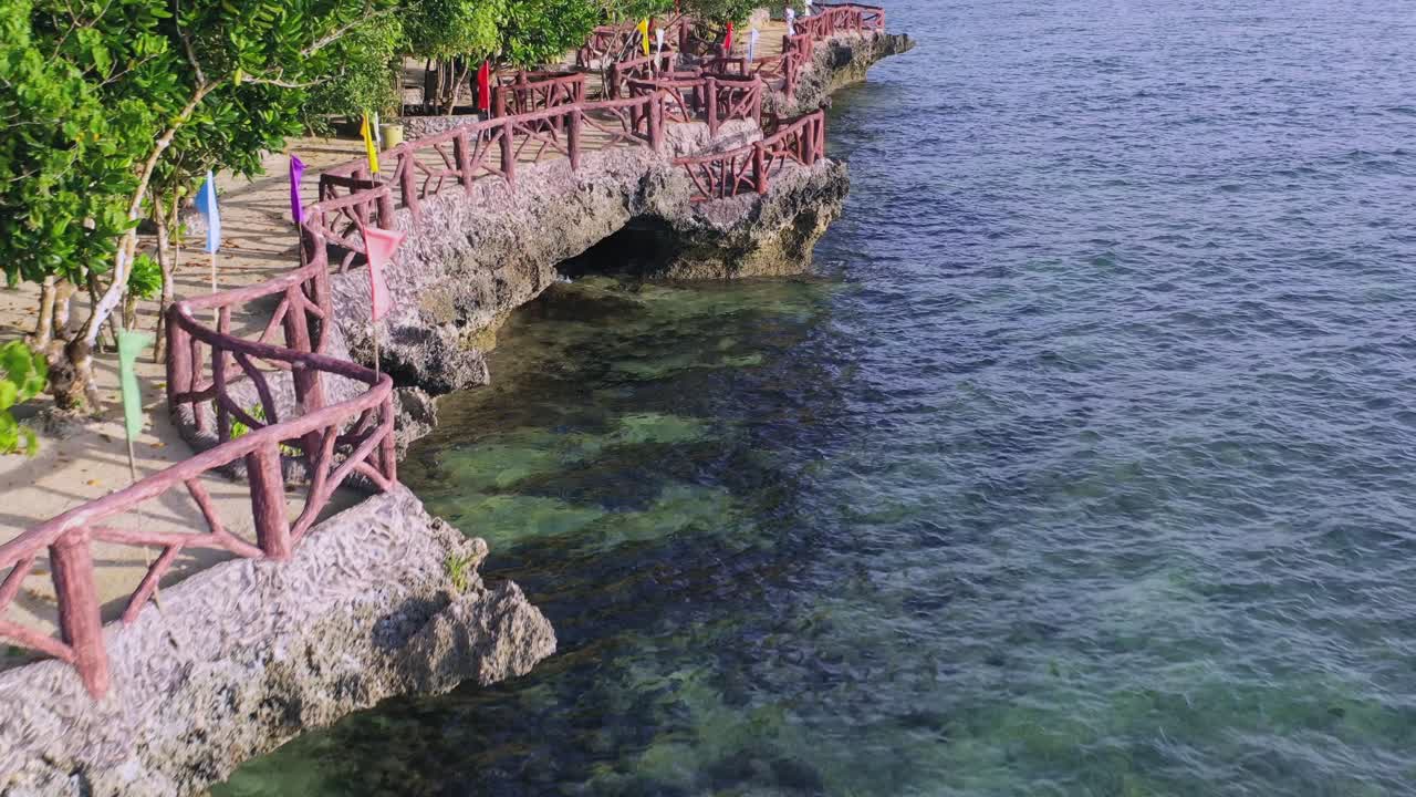 Wide angle dolly out drone shot of walkway in resorts and coastlines-seaside in Boracay island in the Aklan region of Phillipines during the day