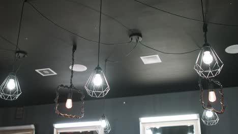 interior de lujo vintage iluminación moderna, colgando en el techo de la barbería. techo gris, paredes grises