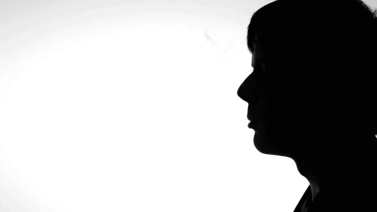 Sagoma di uomo che espira fumo di sigaretta