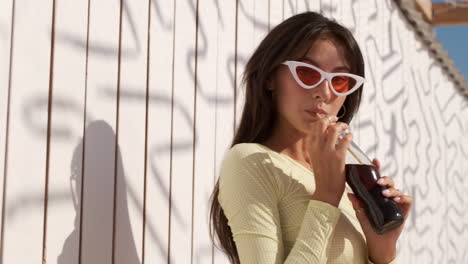 Brunette-girl-drinking-soda-at-the-beach.