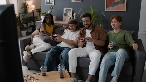 friends playing video games on sofa