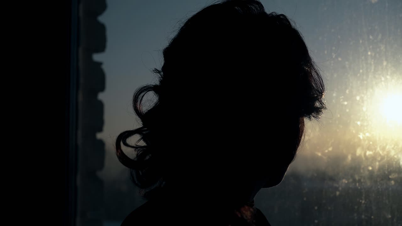 깨 ⁇ 한 창문 클로즈업에서 긴 머리카락을 고정하는 여자의 실루 ⁇