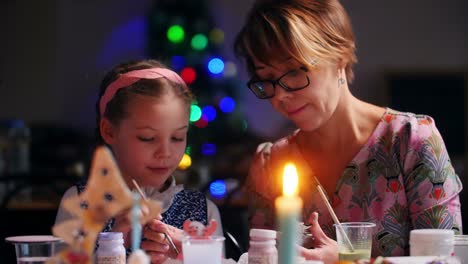 mother and daughter painting christmas decorations