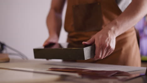 Handwerker-Stellt-Stand-Für-Lederverarbeitung-Auf-Den-Tisch