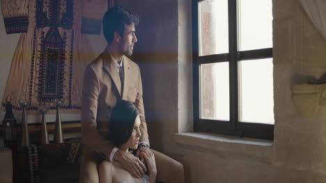 couple sitting by a window in a historic building