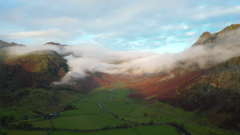 cloud shrouded misty mountains with peaks lit by early morning autumn sunshine