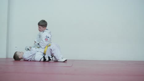 young martial artists in white gi and yellow belts practicing kudo techniques with focus and determination