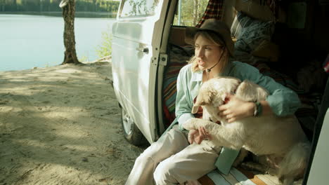 Happy-Female-Tourist-Petting-Golden-Retriever-in-Van