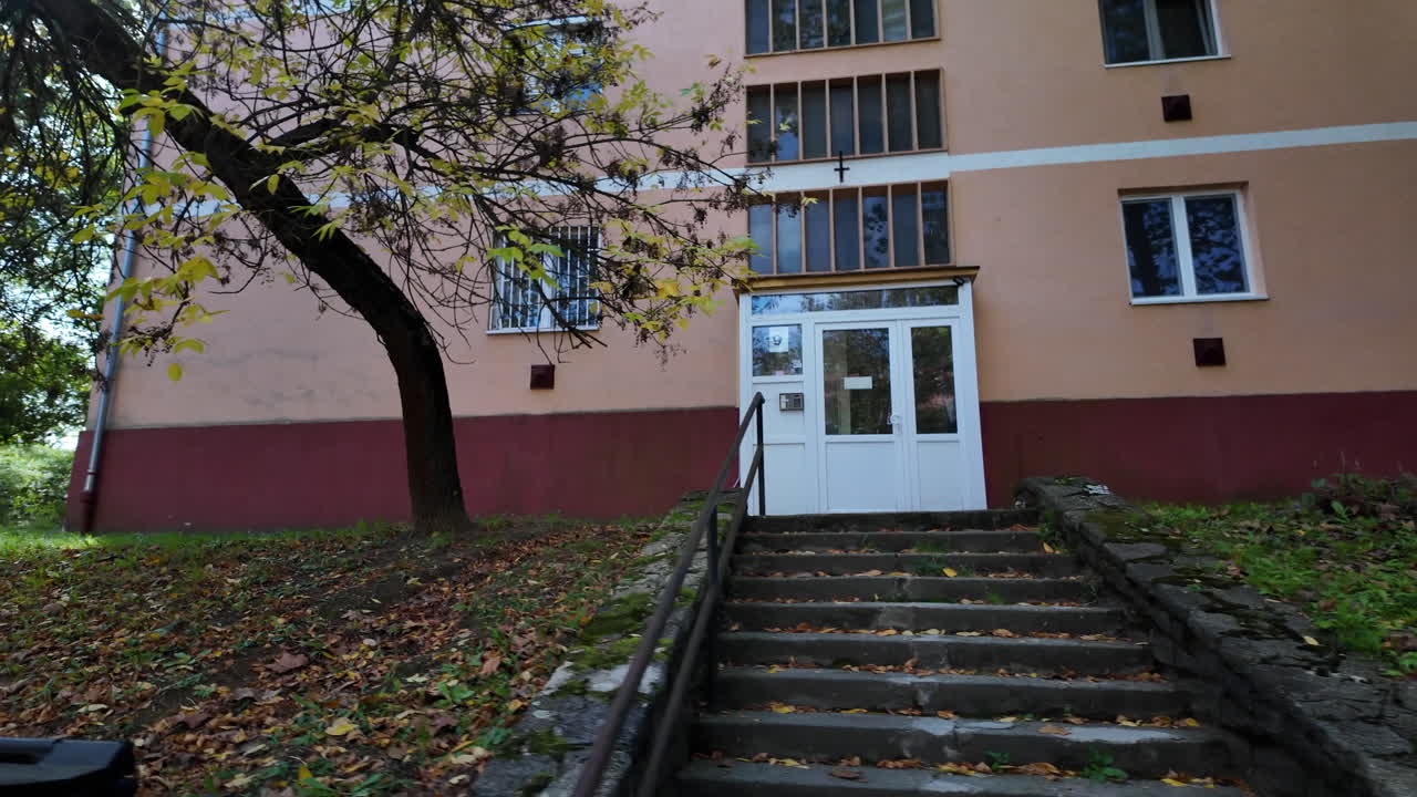 Residential building with autumn trees and fallen leaves
