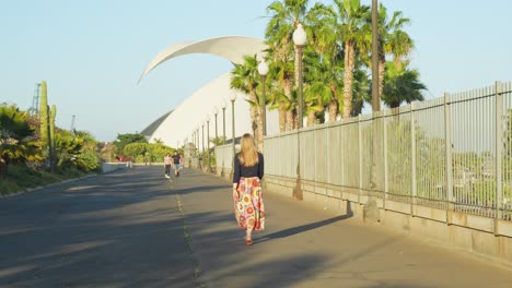 toma trasera de una mujer caminando por la calle en santa cruz, tenerife, hora dorada, slomo.