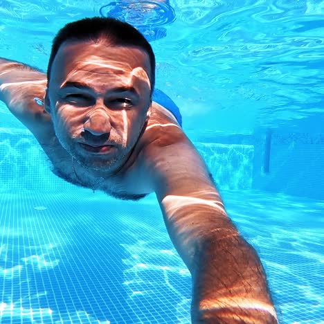 underwater fun. handsome young man swimming in pool. sport and leisure.