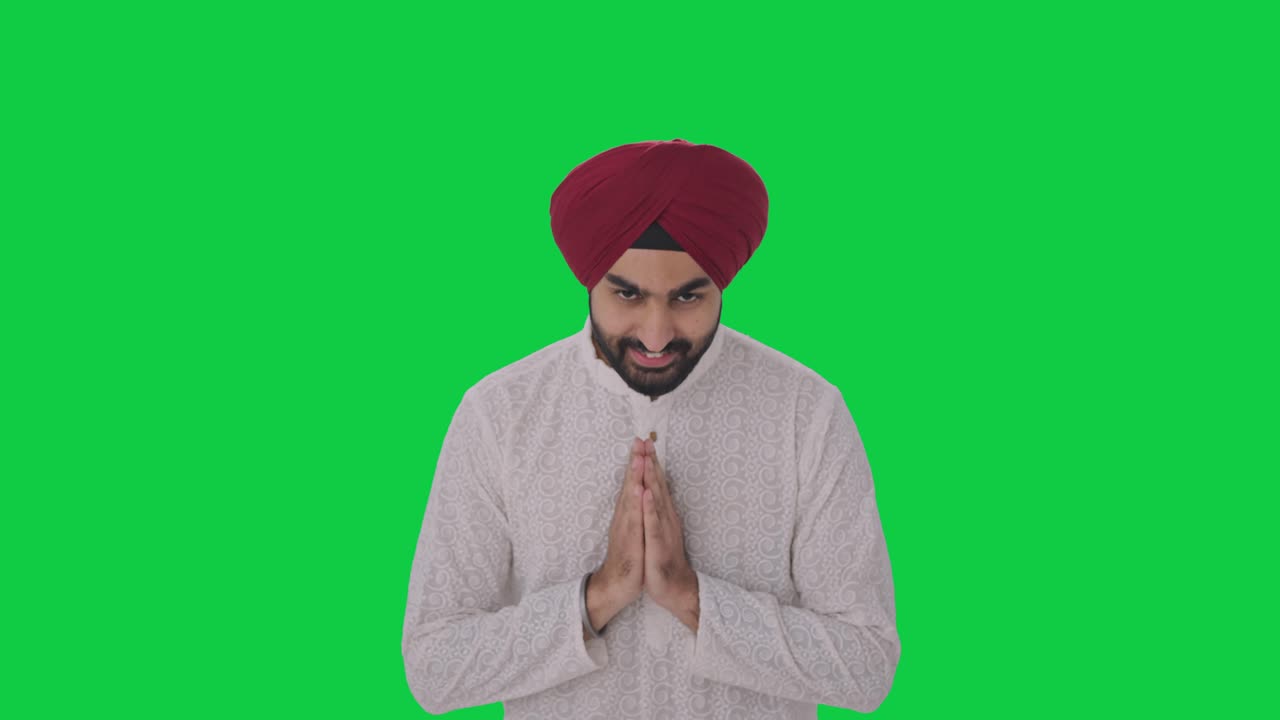 Happy Sikh Indian man doing Namaste Green screen