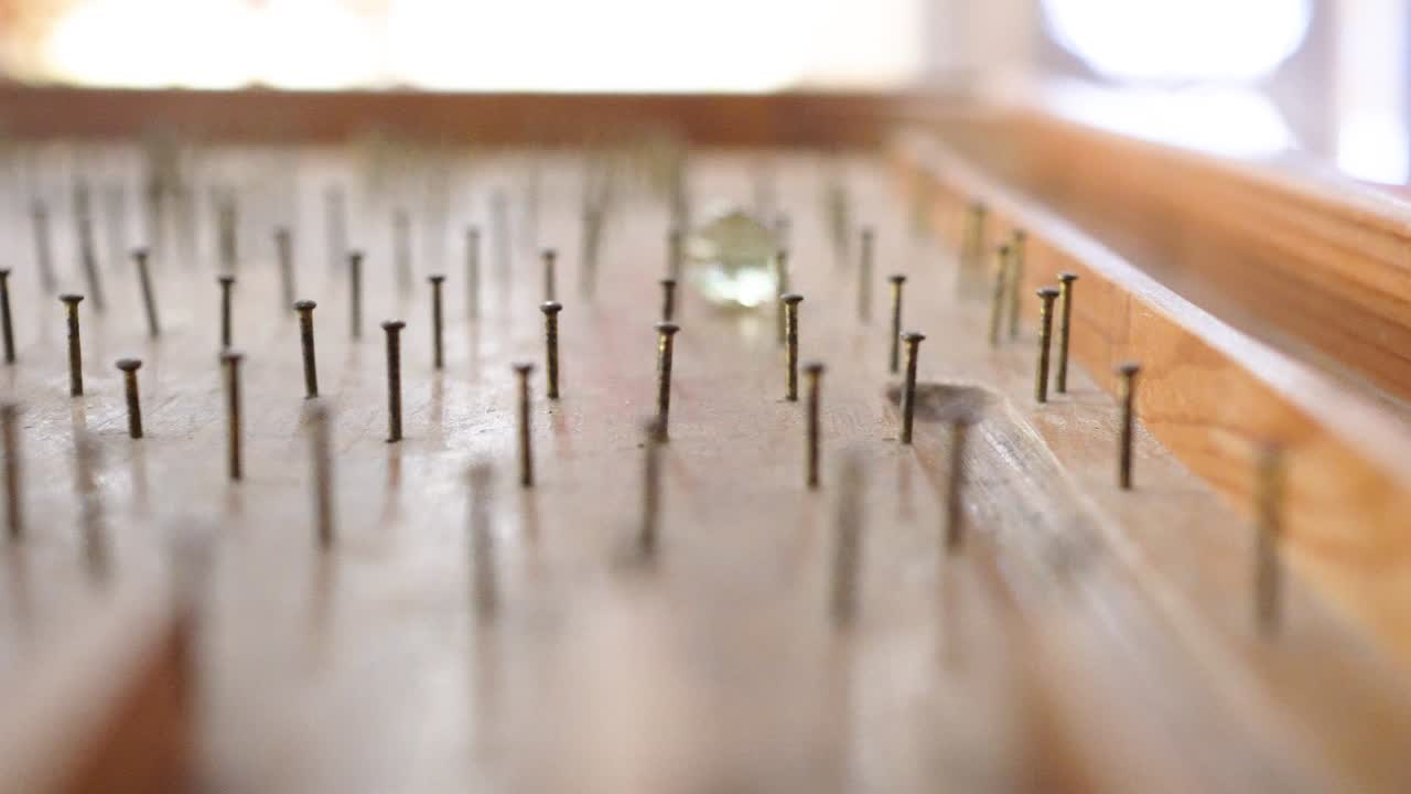 cerca de la mesa de pinball hecha de madera. las cuentas de vidrio rodan hacia abajo en la mesa de flipper. un juego jugado por un niño. el tema está a la derecha.