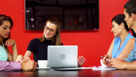 Business-executives-discussing-over-laptop