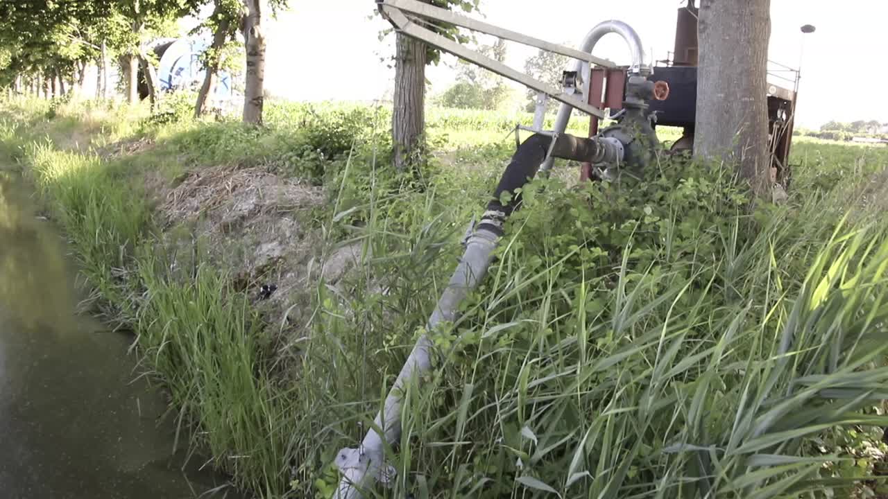 Pumping station pumping water from an irrigation canal and distributed to irrigation sprinklers in farm fields. Irrigation pump machinery.  Agricultural fields getting watered with irrigation water