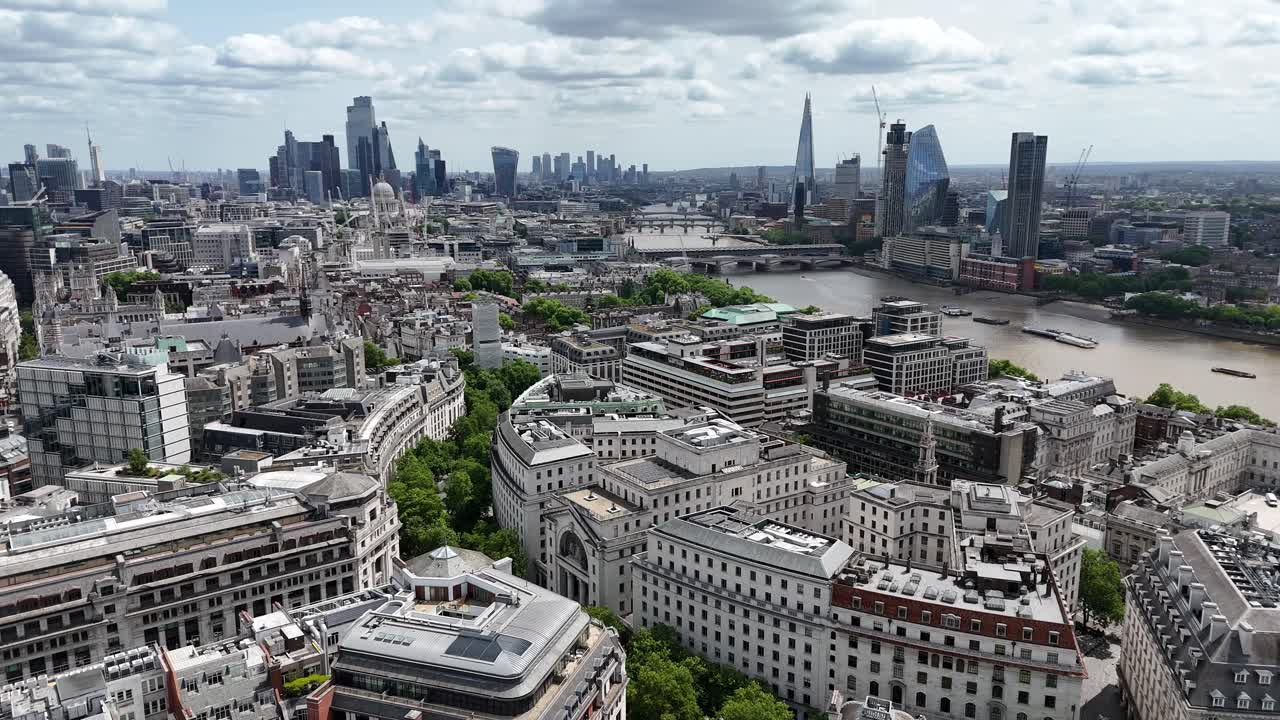 Aerial view soaring southeast over Somerset House and the Temple Gardens, revealing iconic Blackfriars station and the shimmering River Thames under cloudy skies.