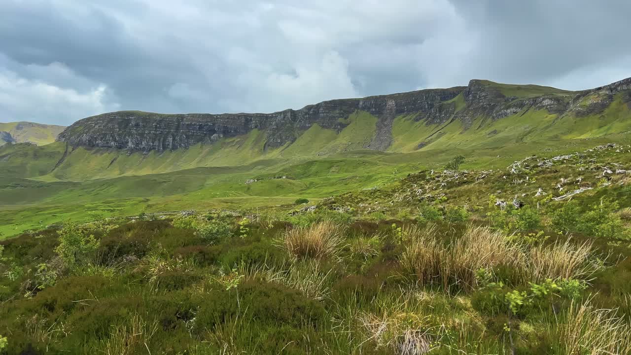Grassy Hills With Loch Leathan Seen From The Old Man of Storr On A Windy Day On the Isle of Skye in Scotland. - wide pan shot